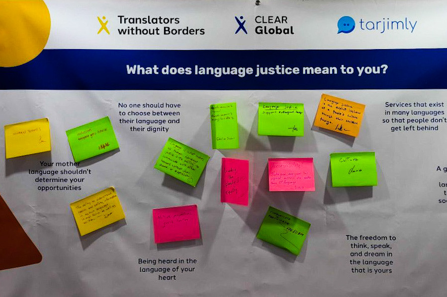En vägg hos Clear Global med frågan "What does language justice mean to you?" och besökarnas svar på post-it-lappar